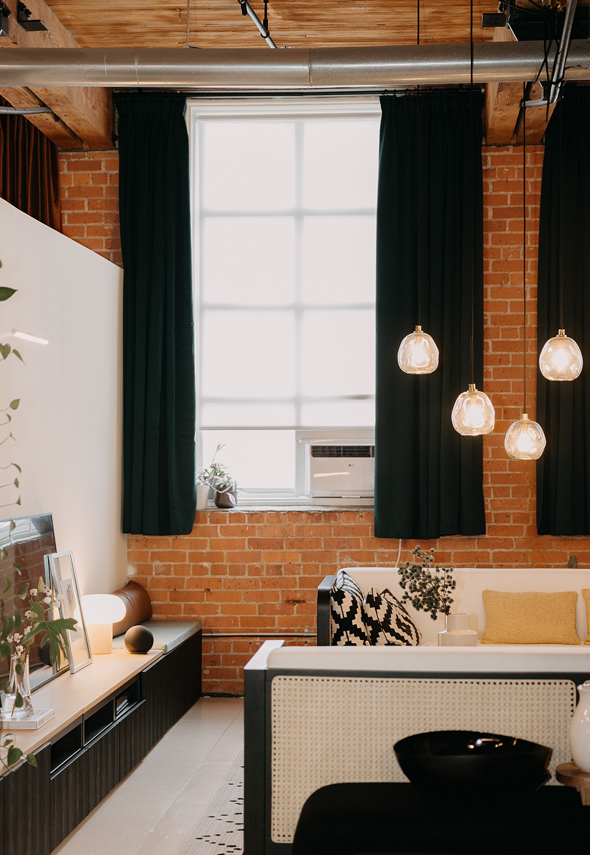an airbnb Detroit home with red brick wall and black curtains
